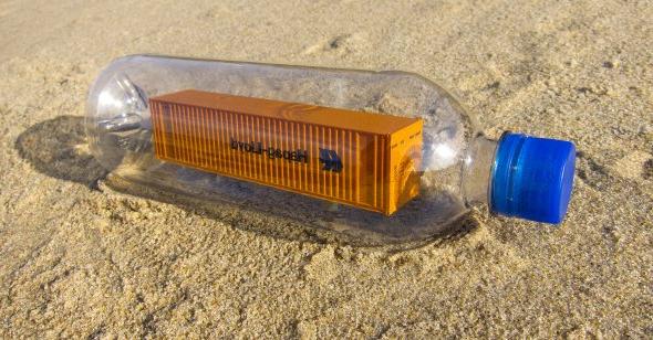 Photo of a shipping container inside a plastic water bottle.